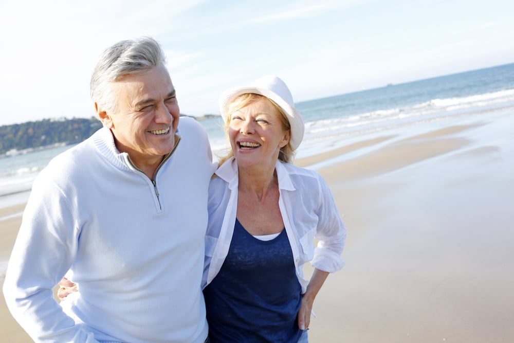 Senior couple walking on the beach in fall season